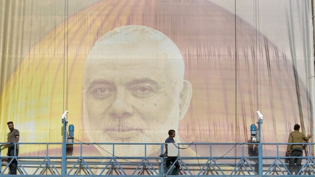 FILE: Iranian workers install a huge banner on a wall showing a portrait of Hamas leader Ismail Haniyeh in Tehran, 31 July 2024