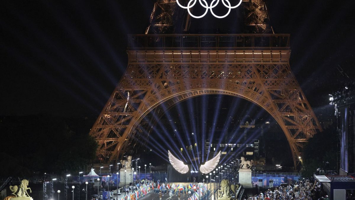 volunteers carrying flags of Olympic teams on the Iena Bridge in Paris, France, during the opening ceremony of the 2024 Summer Olympics, Friday, July 26, 2024.