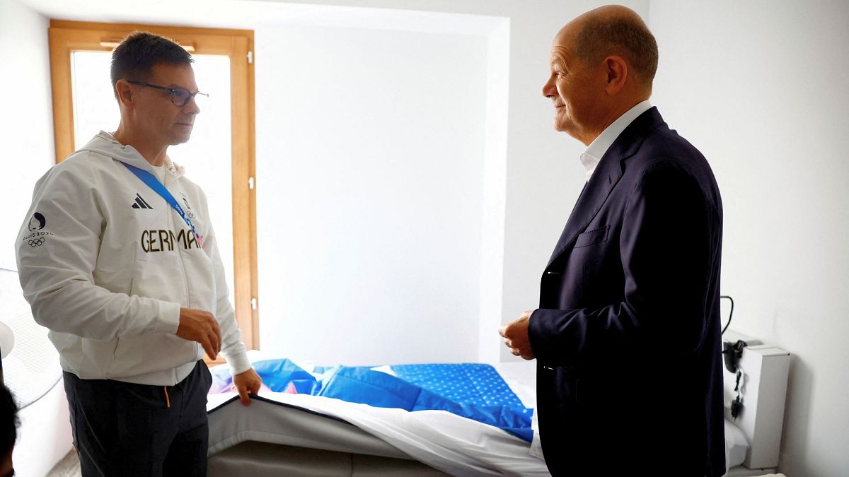 German Chancellor Olaf Scholz, right, visits the Olympic Village with members of the German Olympic team, 27 July 2024, in Paris, France.