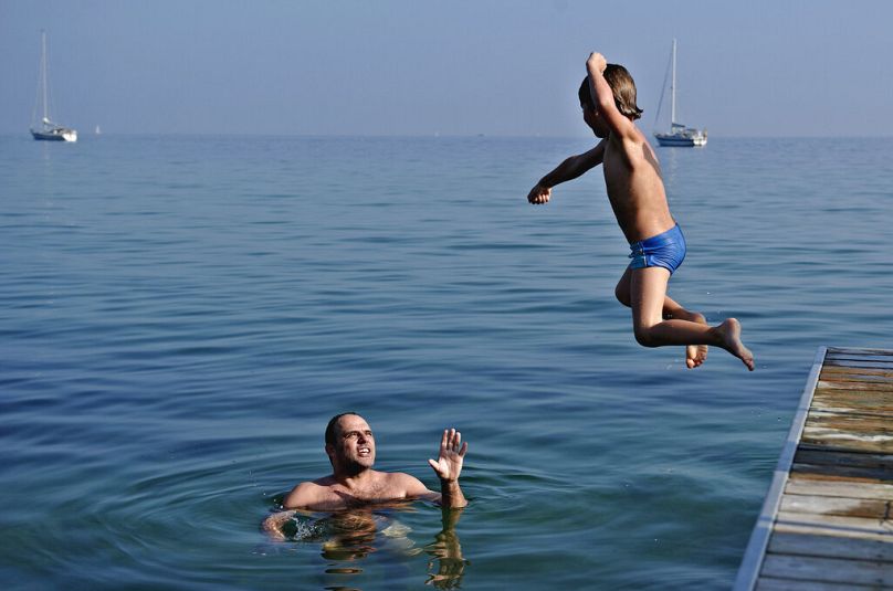 Carsten Vammen i Sebastian cieszą się ciepłą pogodą na plaży Bellevue na północ od Kopenhagi, w sobotę 1 października 2011 r.