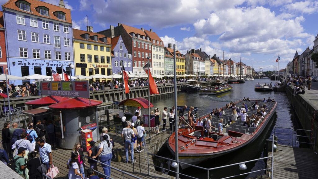 FILE - Tourists in the harbour in Copenhagen, Denmark, during a hot summer day with temperatures over 30 degrees Celsius, Friday, June 18, 2021.