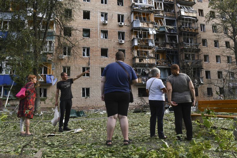 Mieszkańcy budynku mieszkalnego uszkodzonego w wyniku ostrzału przeprowadzonego przez stronę ukraińską stoją w pobliżu budynku w Kursku w Rosji, w niedzielę, 11 sierpnia 2024 r.