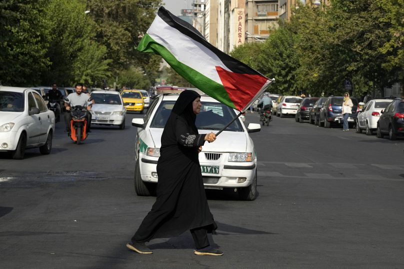 Irańska kobieta niesie flagę palestyńską, aby potępić zabójstwo przywódcy Hamasu Ismaela Haniyeha na placu Felestin (Palestyna) w Teheranie, Iran, środa, 31 lipca 2024 r. 