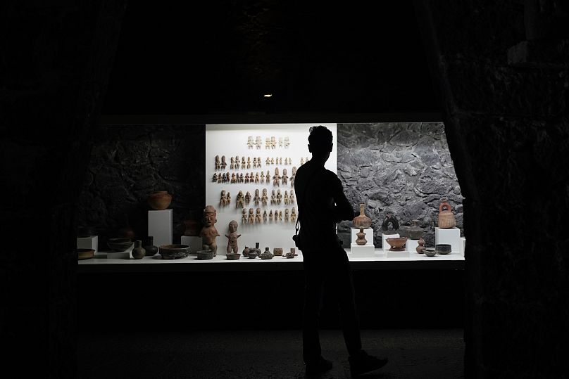 Zwiedzający oglądają ceramikę przedhiszpańską na wystawie w Muzeum Anahuacalli w mieście Meksyk.