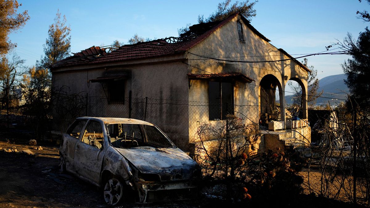 Damaged house and car, which had been burned in a mid-August wildfire, are seen in Halandri suburb in northern Athens, 25 August 2024.