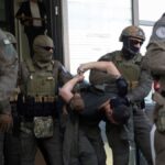 FILE - Kosovo police members escort one of the arrested Serb gunmen out of the court after the Kosovo shootout in capital Pristina, on Tuesday, Sept. 26, 2023.