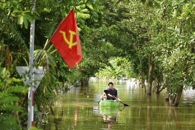 Mężczyzna wiosłuje łódką podczas powodzi po przejściu tajfunu Yagi we wsi An Lac w Hanoi w Wietnamie, piątek, 13 września 2024 r.