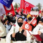 FILE - Supporters of the islamist Ennada party march with Tunisian flags during a rally in Tunis, Tunisia, Saturday, Feb. 27, 2021