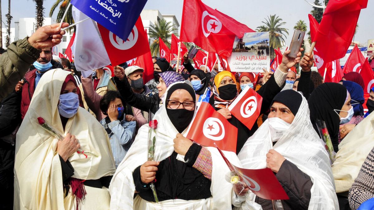 FILE - Supporters of the islamist Ennada party march with Tunisian flags during a rally in Tunis, Tunisia, Saturday, Feb. 27, 2021