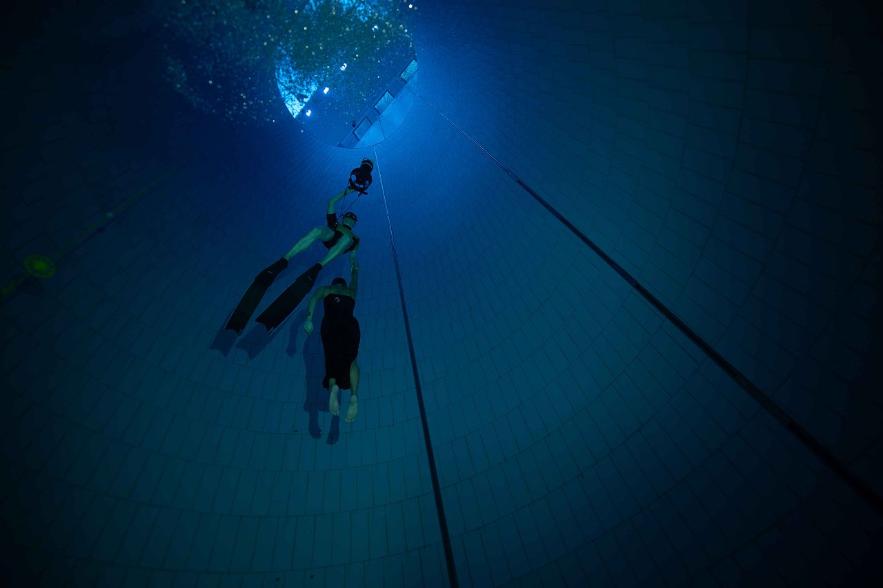 Freediver Christin Gerstorfer i nurek bezpieczeństwa korzystają ze skutera nurkowego, aby wynurzyć się na powierzchnię. Wings in the Deep. 24 sierpnia 2024 r. Warszawa, Polska.