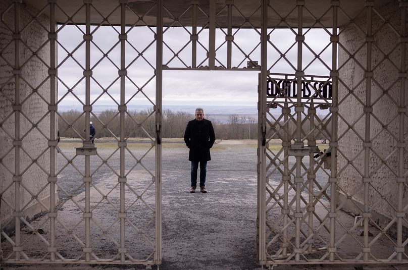 Szef Pomnika Buchenwald, Jens-Christian Wagner, pozuje do zdjęcia za główną bramą byłego nazistowskiego obozu koncentracyjnego w Weimarze w Niemczech, w środę 31 stycznia