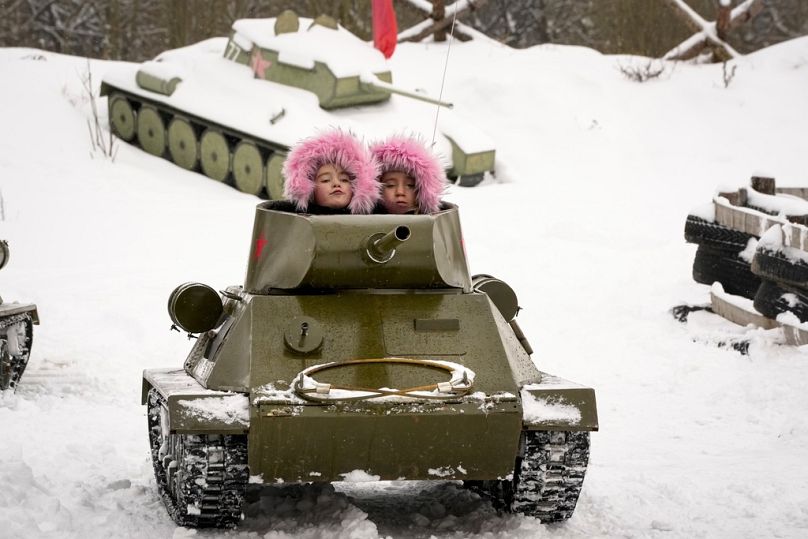 Dzieci jadą modelem radzieckiego czołgu T-34 z czasów II wojny światowej podczas festiwalu historyczno-wojskowego w rodzinnym parku czołgów na obrzeżach Petersburga, 4 lutego 2023 r.