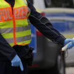 A German federal police officer stops cars and trucks at a border crossing point