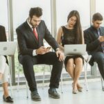 Four people sitting and waiting for interviews