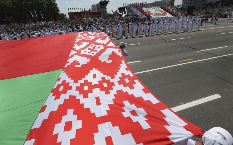 Białoruscy sportowcy niosą flagę kraju podczas obchodów Dnia Niepodległości w Mińsku na Białorusi, 3 lipca 2013 r. 