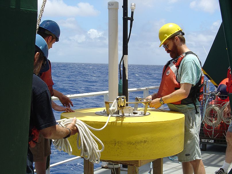 Chemik morski Ken Buesseler pracuje przy cumowaniu typu „klaps – pułapka” podczas projektu Vertical Transport In the Global Ocean (VERTIGO) w 2004 roku.