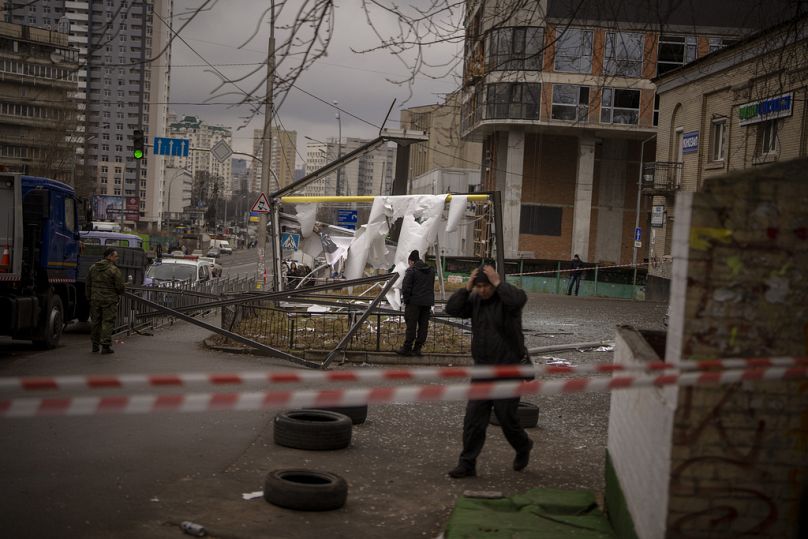 Policjanci kontrolują teren po pozornym rosyjskim strajku w Kijowie na Ukrainie, czwartek, 24 lutego 2022 r. 