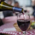 FILE: A customer pours a glass of Beaujolais Nouveau wine in a restaurant of Boulogne Billancourt, outside Paris, Thursday, Nov. 18, 2021.