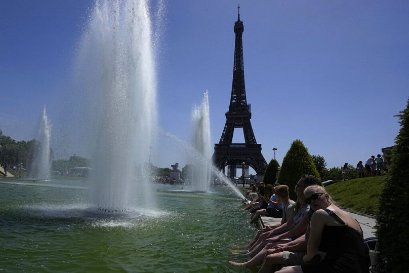 Ludzie ochładzają się na fontannach Trocadero w Paryżu. 